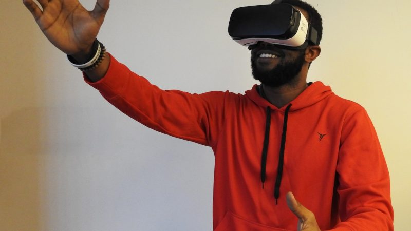 man wearing white VR headset while lifting right hand